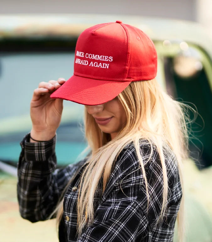 Woman wearing Make Commies Afraid Again hat. 